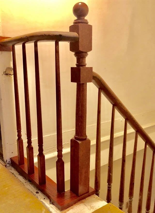 Wood handrail and balusters at a stair landing
